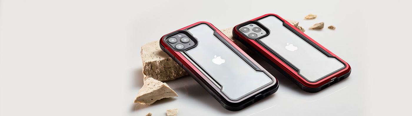 Two iPhone 12 Pro phones lay side-by-side, covered with red and red to black gradient cases from Raptic.